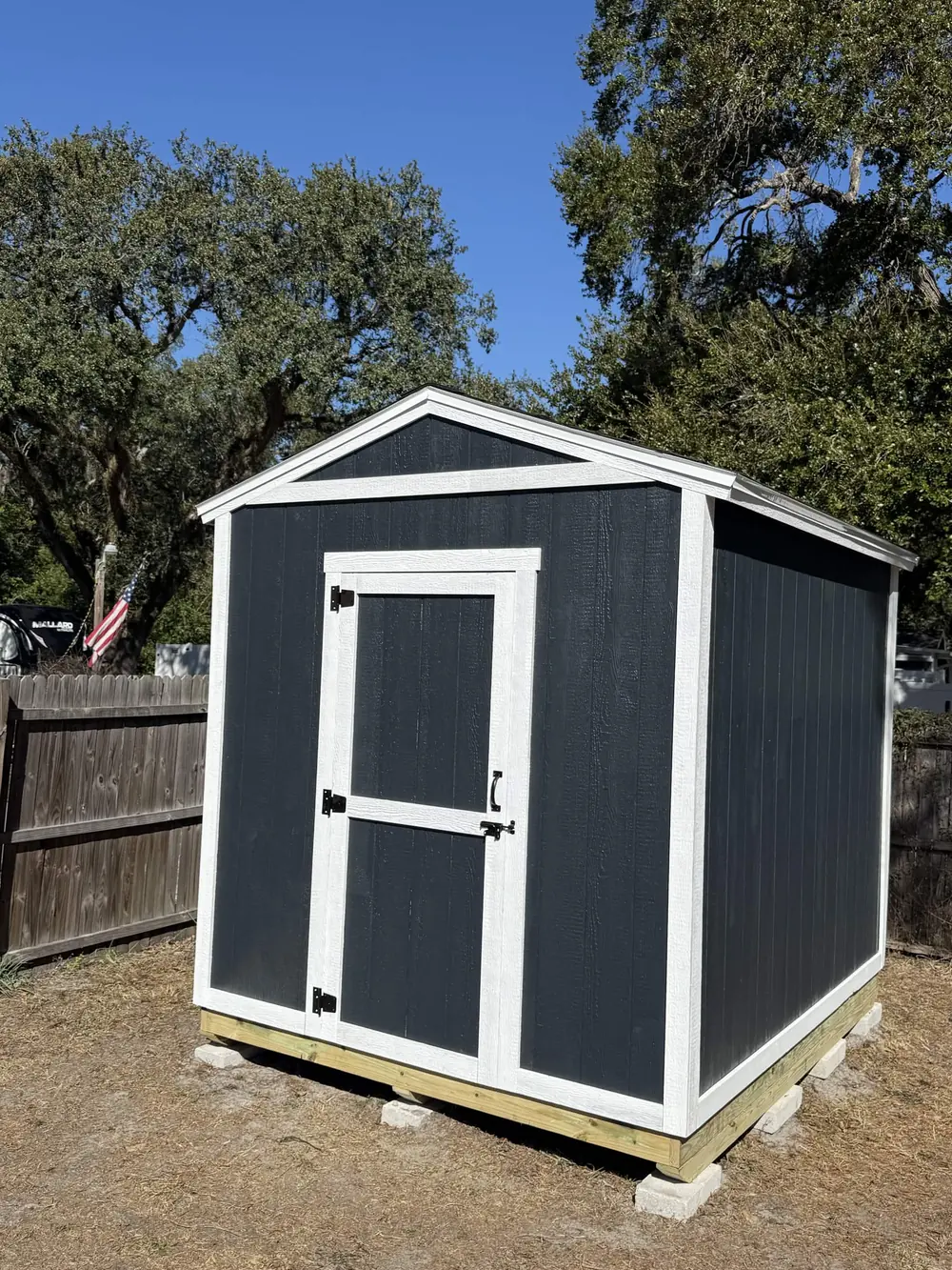 Compact navy custom storage shed with white double doors