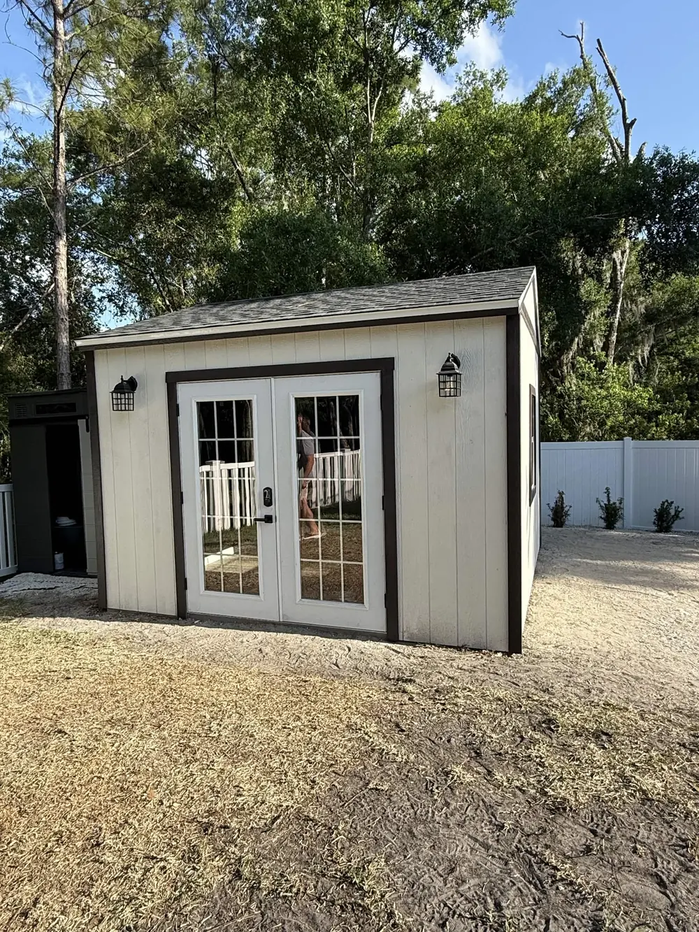 Modern white custom shed with double glass doors built by Patriot Outdoor Services