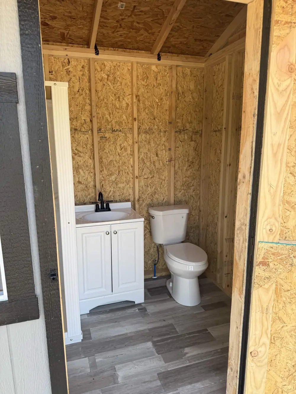 Finished multi-use shed interior with bathroom fixtures